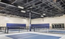 black acoustic baffles hanging from pickleball court ceiling
